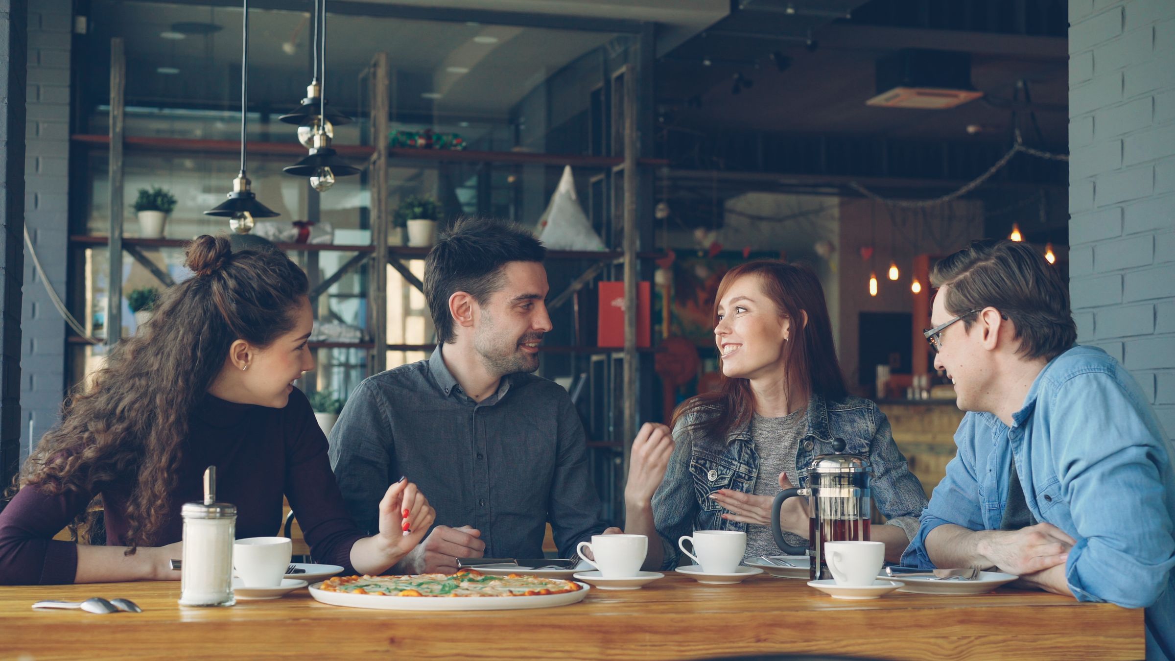 Friends connecting over conversation in a cafe; illustrative stock photograph